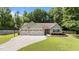 Charming single-story home with a well-manicured lawn, three-car garage, and extended driveway with basketball hoop at 123 Terawood Farm Dr, Willow Springs, NC 27592
