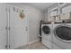 Bright laundry room with modern appliances, white cabinets, and a convenient door to the exterior at 123 Terawood Farm Dr, Willow Springs, NC 27592