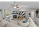 Bright living room features a fireplace, vaulted ceilings with ceiling fan, and a large sectional sofa at 123 Terawood Farm Dr, Willow Springs, NC 27592