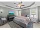 Serene main bedroom with a tray ceiling, plush bed, stylish decor, and ample natural light, creating a restful retreat at 123 Terawood Farm Dr, Willow Springs, NC 27592