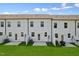 Townhome exteriors feature small, fenced backyard spaces with modern design under a partly cloudy blue sky at 140 Camel Crazies Pl # 39, Lillington, NC 27546