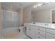 Well-lit bathroom features a shower-tub combo, white vanity, and patterned wallpaper at 191 Nc 56, Louisburg, NC 27549