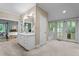 Expansive bathroom with large mirror, white vanity, and French doors leading to balcony with treetop views at 191 Nc 56, Louisburg, NC 27549