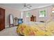 Bright bedroom featuring a floral patterned bedspread, two windows, a ceiling fan, and an antique dresser at 191 Nc 56, Louisburg, NC 27549