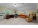 Comfortable bonus room offering versatile space with an arched window, an orange sofa and a desk at 191 Nc 56, Louisburg, NC 27549