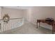 Upstairs hallway with curved railing, plush carpet, and pink walls at 191 Nc 56, Louisburg, NC 27549