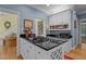 Kitchen with white cabinets, black countertops, gas cooktop on island, and adjacent living area at 191 Nc 56, Louisburg, NC 27549