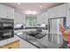 Modern kitchen with white cabinets, stainless steel appliances, and a gas cooktop on a black granite island at 191 Nc 56, Louisburg, NC 27549