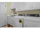 Functional laundry room with white cabinetry, sink, and side-by-side washer and dryer at 191 Nc 56, Louisburg, NC 27549