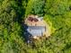 An aerial view of a well-maintained home with a dark gray roof surrounded by a lush green forest at 2100 Fort Dr, Clayton, NC 27520