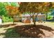 Well-maintained backyard with mature trees, including a wooden swing set and outdoor seating, providing a serene outdoor space at 2100 Fort Dr, Clayton, NC 27520