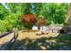 Expansive backyard featuring mature trees, well-maintained lawn, sheds, and a wooden deck, perfect for outdoor living at 2100 Fort Dr, Clayton, NC 27520