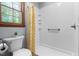 Bright bathroom features a white tiled shower with a yellow patterned curtain and a window offering natural light at 2100 Fort Dr, Clayton, NC 27520