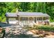 Charming single-story home with a welcoming front porch and attached garage, surrounded by lush greenery at 2100 Fort Dr, Clayton, NC 27520