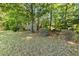 Well-maintained backyard features mature trees and landscaping, offering a peaceful retreat at 217 Braxcarr St, Holly Springs, NC 27540