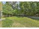 Expansive backyard with lush green grass and mature trees creating a serene outdoor space at 217 Braxcarr St, Holly Springs, NC 27540