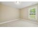 Comfortable carpeted bedroom features a large window and neutral-colored walls at 217 Braxcarr St, Holly Springs, NC 27540