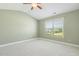 Bright bedroom featuring plush carpet, a ceiling fan, and a large window with natural light at 217 Braxcarr St, Holly Springs, NC 27540