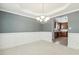 Dining room with chair rail, modern chandelier, and archway leading to the kitchen at 217 Braxcarr St, Holly Springs, NC 27540