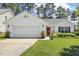 Charming one-story home features a red front door, an attached garage, and manicured lawn at 217 Braxcarr St, Holly Springs, NC 27540
