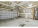 Spacious garage with roll-up door, featuring ample room for parking and storage at 217 Braxcarr St, Holly Springs, NC 27540