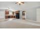 Open-concept kitchen with wood cabinets, modern appliances, ceiling fan, and adjoining living space at 217 Braxcarr St, Holly Springs, NC 27540