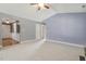 Open living area with a view of the entryway, and neutral walls with ceiling fan at 217 Braxcarr St, Holly Springs, NC 27540
