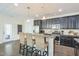 Modern kitchen with stainless steel appliances, granite countertops, and breakfast bar seating at 221 Mayfield Dr, Apex, NC 27539