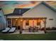Backyard view featuring a pergola-covered patio with bistro lighting, dining set, lounge chairs, and manicured lawn at 24 Sweet Birch Row, Youngsville, NC 27596