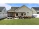 Well-manicured backyard featuring a pergola-covered patio, lounge chairs, dining set, and landscaped yard at 24 Sweet Birch Row, Youngsville, NC 27596