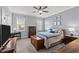 Bedroom with a fan, neutral color walls, with furnishings including trunk, desk, dressers, and bed at 24 Sweet Birch Row, Youngsville, NC 27596