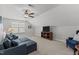 Well-lit bonus room featuring comfortable seating, entertainment center, ceiling fan, and neutral carpeting at 24 Sweet Birch Row, Youngsville, NC 27596