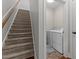 Hallway view featuring a staircase and an entrance to a laundry room with modern washer and dryer at 24 Sweet Birch Row, Youngsville, NC 27596