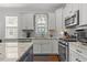 Modern kitchen featuring white cabinets, stainless steel appliances, and granite countertops at 24 Sweet Birch Row, Youngsville, NC 27596