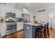 Modern kitchen with white cabinets, stainless steel appliances, granite countertops, and a stylish center island at 24 Sweet Birch Row, Youngsville, NC 27596