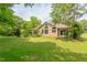 Spacious backyard view of a beautiful home with lush greenery and a patio at 313 Helmsdale Dr, Chapel Hill, NC 27517
