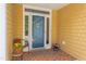 Inviting front porch with brick flooring, a chair with colorful flowers, and a screen door providing a warm welcome at 313 Helmsdale Dr, Chapel Hill, NC 27517