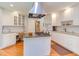 Eat-in kitchen featuring gas range, granite countertops, white cabinets, hardwood floors, and desk space at 313 Helmsdale Dr, Chapel Hill, NC 27517