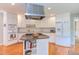Bright kitchen features a center island, stainless steel appliances, white cabinetry, and hardwood floors at 313 Helmsdale Dr, Chapel Hill, NC 27517