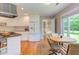 Eat-in kitchen featuring white cabinets, stainless appliances, large window with backyard views, and table with seating at 313 Helmsdale Dr, Chapel Hill, NC 27517