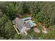 Beautiful aerial view of the home, showcasing the pool, firepit and surrounding wooded acreage at 3653 Range Rd, Stem, NC 27581
