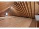 Unfinished attic space with exposed wooden beams and plywood flooring at 3653 Range Rd, Stem, NC 27581