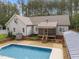 Backyard featuring a deck, swimming pool, screened porch and covered grilling area at 3653 Range Rd, Stem, NC 27581