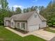 Charming home exterior showcasing a well-manicured lawn, inviting garage, and beautifully landscaped surroundings at 3653 Range Rd, Stem, NC 27581