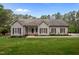 Charming single-story home featuring a manicured lawn, symmetrical windows, and professional landscaping at 3653 Range Rd, Stem, NC 27581