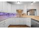 Kitchen with white cabinets, granite counters, tile backsplash and wood floors at 3653 Range Rd, Stem, NC 27581