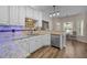 Kitchen with stainless steel appliances, tile backsplash, granite counters and wood floors at 3653 Range Rd, Stem, NC 27581