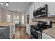 Kitchen with stainless steel appliances, granite counters, and a view of the breakfast area at 3653 Range Rd, Stem, NC 27581