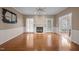 Bright living room featuring hardwood floors, a cozy fireplace, and an open view into the adjacent dining area at 3653 Range Rd, Stem, NC 27581