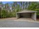 Large outbuilding with a gravel floor surrounded by mature trees at 3653 Range Rd, Stem, NC 27581